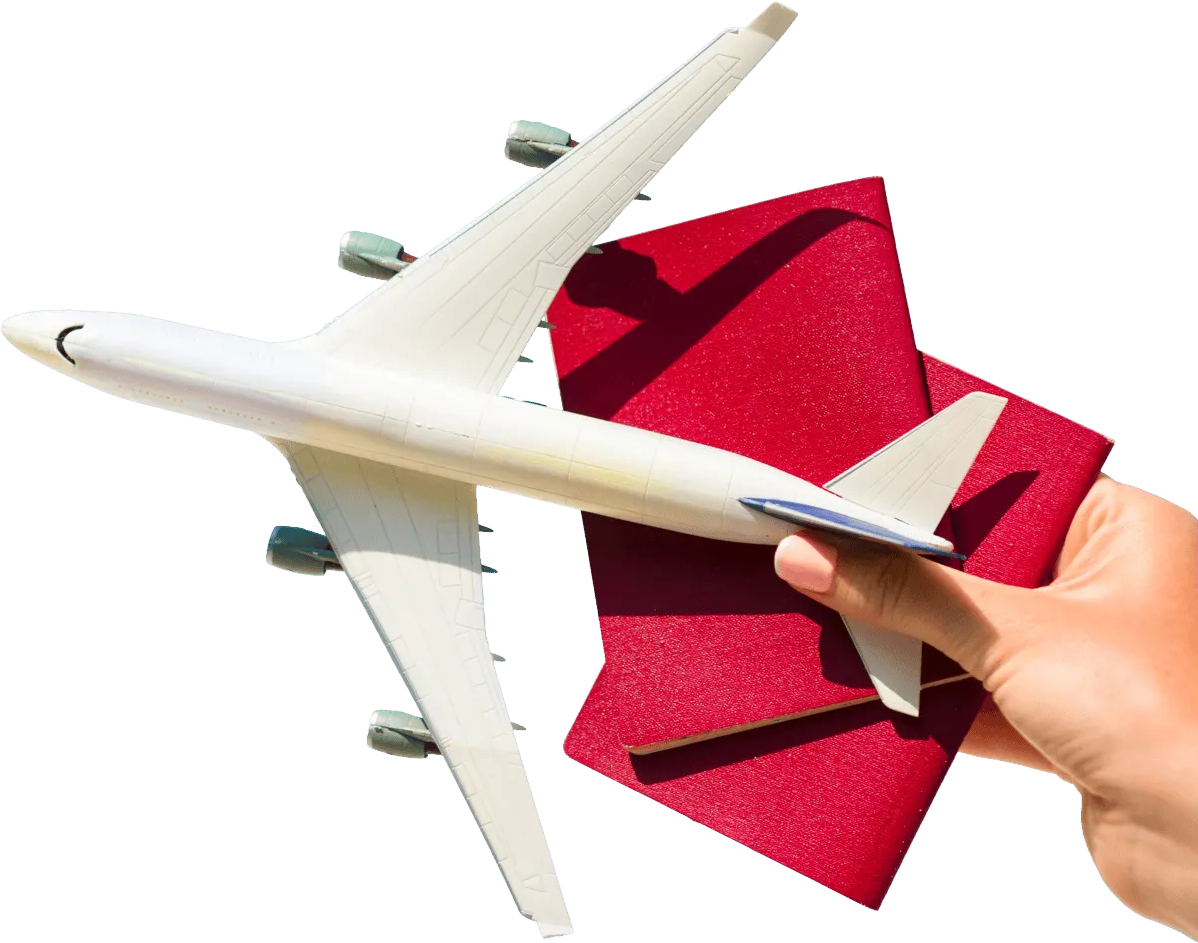 Hand holding a toy airplane over two red passports, conveying travel planning or booking.